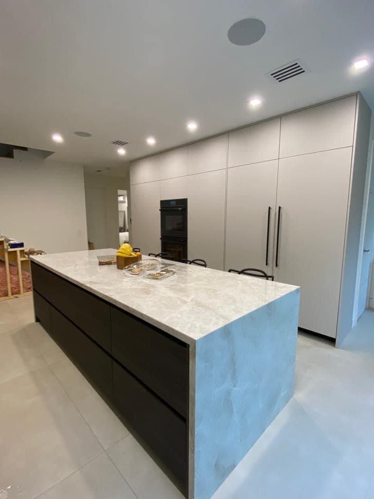 Waterfall island kitchen with two-tone cabinetry