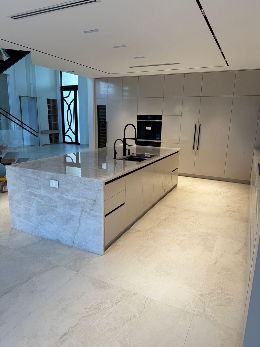 Kitchen with marble island and dark cabinetry