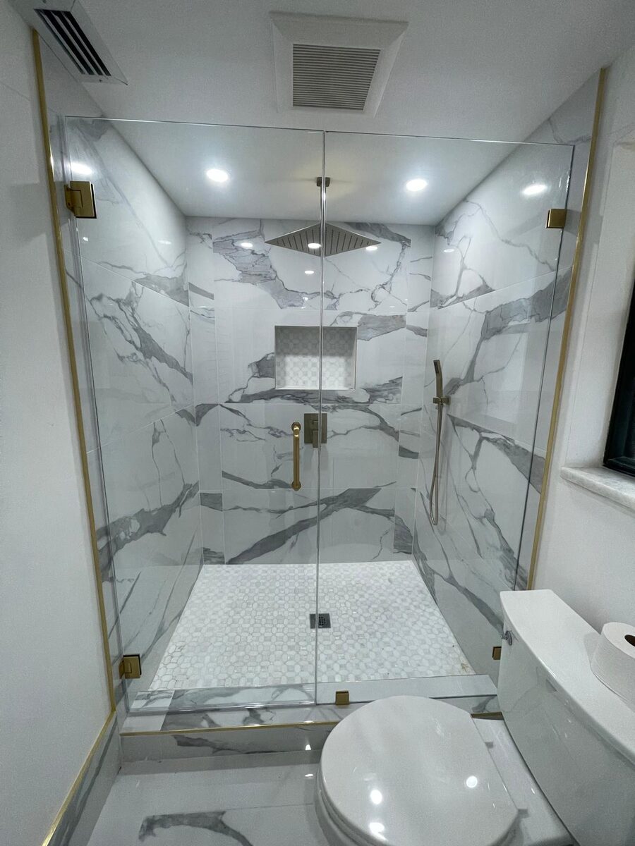 Bathroom with marble shower and gold fixtures